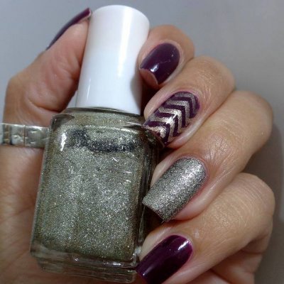 Frasco de verniz de unhas prata com mão pintada em verniz violeta e prateado