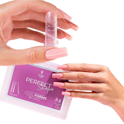 Unhas postiças rosadas foscas em mãos femininas com embalagem roxa transparente de unhas postiças