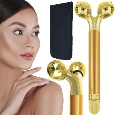 Dispositivo de massagem facial dourado com duas esferas facetadas e bolsa preta