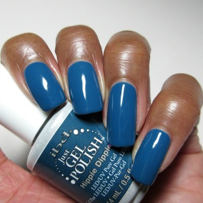 Unhas com verniz gel azul petróleo e frasco com texto ibd Just GEL POLISH