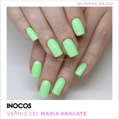 Unhas com verniz gel verde claro brilhante em fundo branco