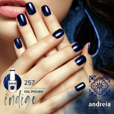 Mãos femininas com unhas pintadas de verniz gel azul índigo metálico e embalagem de verniz. 