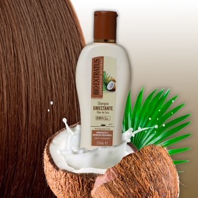 Shampoo Biodextratus com óleo de coco em destaque dentro de coco partido e folhas verdes