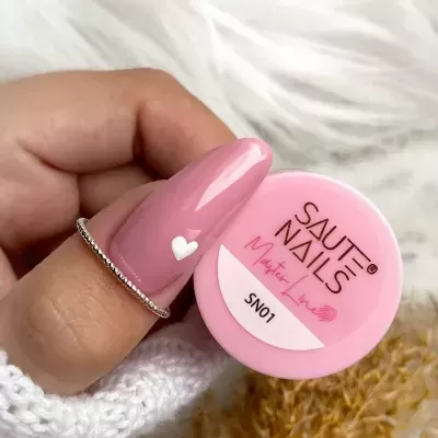 Frasco rosa de verniz para unhas com mão segurando e unha rosa com coração branco