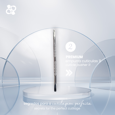 Empurrador de cutículas metálico prateado com textura antiderrapante exposto num suporte transparente