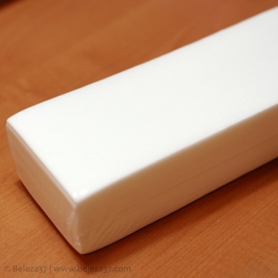 Esponja retangular branca sobre superfície de madeira