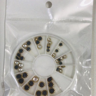 Peças para decoração de unhas em roda organizadora dentro de embalagem plástica transparente