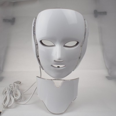 Máscara facial branca futurista com base e cabos USB em fundo cinzento