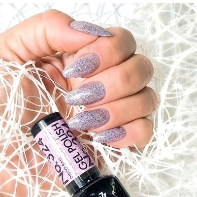 Unhas longas com verniz gel lilás glitter segurando frasco de esmalte preto com rótulo