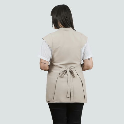 Colete feminino bege com cinto na cintura, visto de costas, usado com t-shirt branca e calças pretas