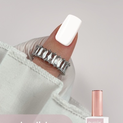 Unha com verniz de gel branco e anel prateado com pedras, com texto e embalagem de verniz ao lado
