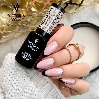 Frasco de verniz gel Victoria Vynn e mão feminina com unhas rosa claro e glitter