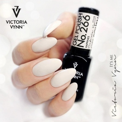 Mão segurando verniz gel Victoria Vynn com unhas brancas foscas