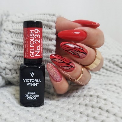 Unha decorada com verniz vermelho e rosa brilhante e desenho preto, segurando frasco de verniz gel Victoria Vynn