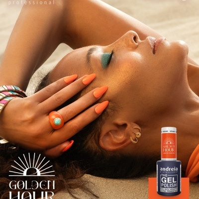 Modelo com unhas laranja vibrante e verniz gel Andreia Golden Hour na areia