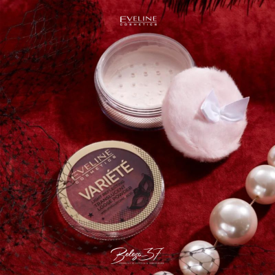 Pó solto translúcido Varieté Eveline Cosmetics com aplicador macio branco sobre tecido vermelho com pérolas.
