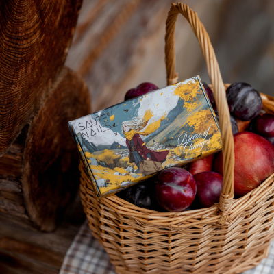 Caixa ilustrada de produto para unhas numa cesta de verga com frutas