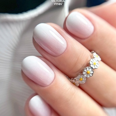 Unhas em gradiente branco brilhante e anel de flores metálicas