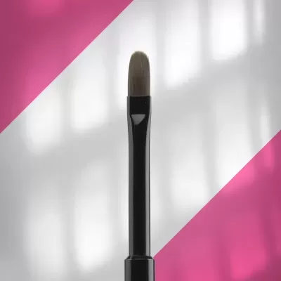 Pincel de maquilhagem preto com cerdas castanho claro em fundo branco e rosa.