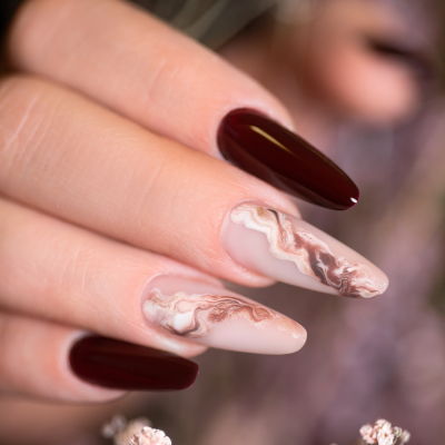 Unhas decoradas com verniz castanho escuro e design marmoreado em bege e castanho