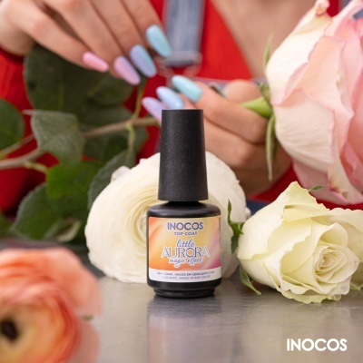 Verniz de unhas INOCOS Little Aurora com flores ao redor e mãos a pintar unhas ao fundo