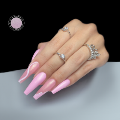 Mão com unhas rosas compridas e anéis prateados sobre fundo preto