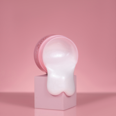 Frasco de gel branco escorrendo sobre cubo rosa em fundo rosa