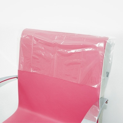 Cadeira cor-de-rosa com encosto parcialmente coberto por plástico transparente