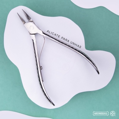 Alicate para unhas metálico prateado com mola sobre fundo branco e verde