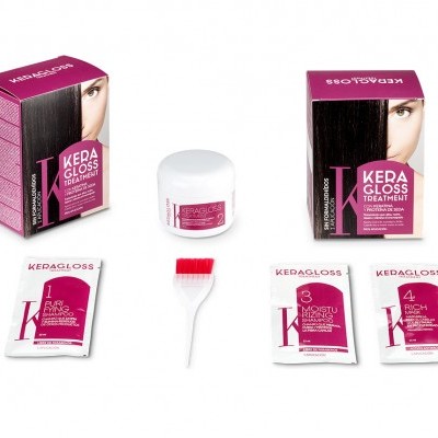 Conjunto de tratamento capilar KEDAGLOSS com caixa rosa e preta, frasco branco, sachês e escova pequena.