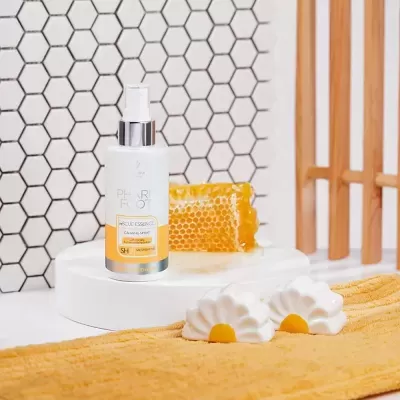 Frasco de spray de produto PHARM PHOT com favo de mel e sabonetes em toalha laranja