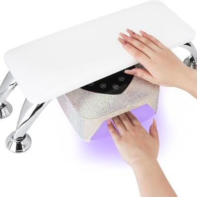 Aparelho de secar unhas com luz UV em uso sobre apoio branco com pernas cromadas