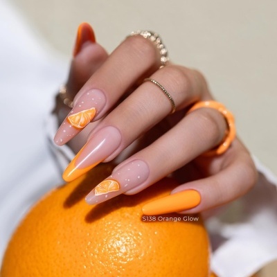 Manicure com unhas laranja e nude, decoração de laranja, mão a segurar uma laranja