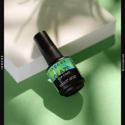 Frasco preto de verniz top coat Inocos sobre superfície verde e branca