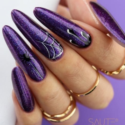Unhas em verniz roxo cintilante com desenhos de teia de aranha, aranha e gotas brancas.