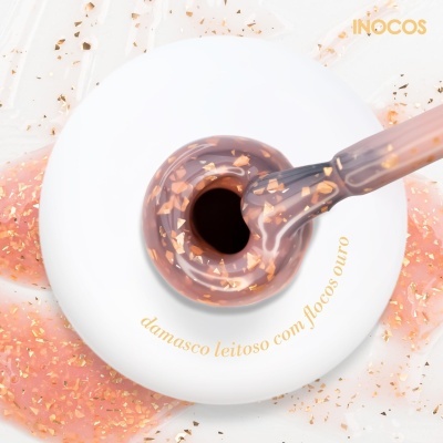 Frasco branco de verniz de unhas damasco leitoso com flocos dourados e pincel aplicador