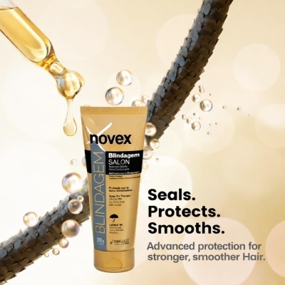 Tubo dourado de Novex Blindagem Salon com fundo bege e gotas de óleo