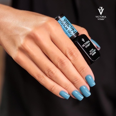 Mão com unhas azuis segurando frasco de verniz Victoria Vynn