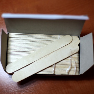 Caixa aberta com pauzinhos de madeira para aplicação de cera