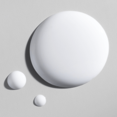 Três gotas de líquido branco em fundo cinza