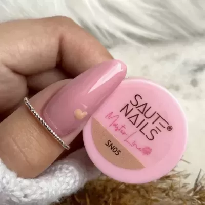 Esmalte para unhas rosa claro SAUTE NAILS SN05 junto a unha com anel