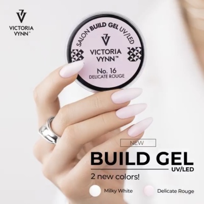 Pote de gel UV/LED Victoria Vynn No. 16 Delicate Rouge com mão feminina segurando o pote e unhas pintadas de cor clara.