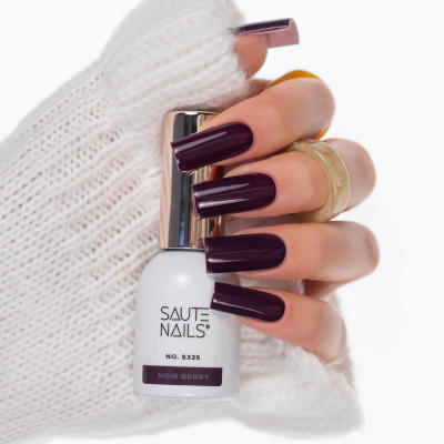Mão com unhas vinho escuro segurando verniz SAUTE NAILS Noir Berry