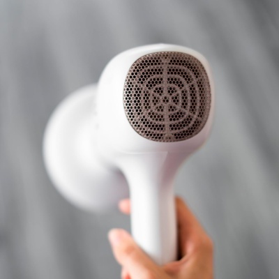 Secador de cabelo branco com grelha metálica hexagonal