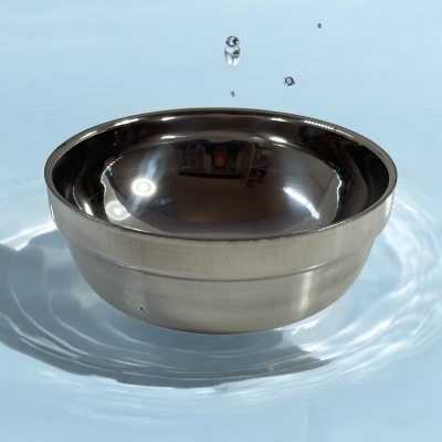 Taça de metal inoxidável sobre água azul clara com gotas de água