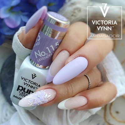 Mãos com unhas decoradas e frasco de verniz de cor lavanda