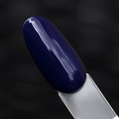 Verniz de unha azul escuro num suporte transparente sobre fundo negro