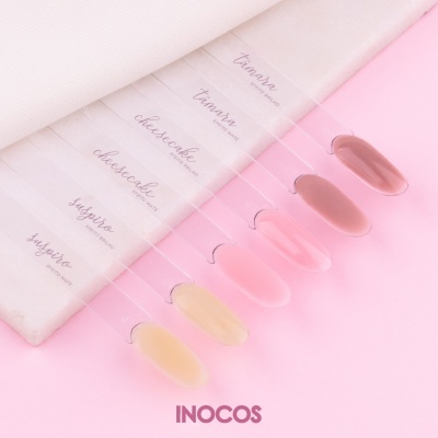 Swatches de vernizes para unhas em tons nude, rosa e castanho com etiquetas e logo INOCOS