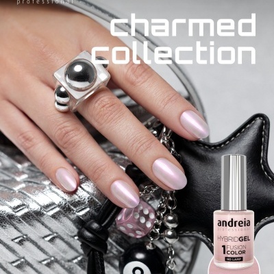 Mão com unhas rosa perolado da charmed collection da andreia professional, com anel prateado e acessórios em fundo metalizado.