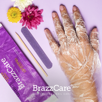Mão com luva plástica transparente e acessórios de manicure, flores coloridas, embalagem BrazzCare